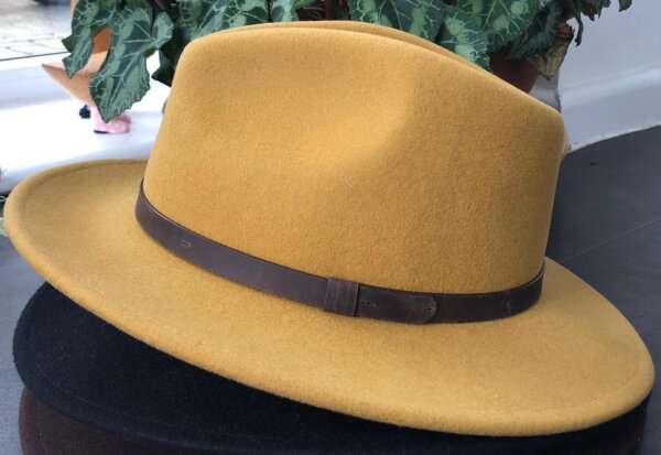 WhatsApp Image 2021 01 29 at 09.12.47 1 Yellow wool felt fedora hat with feather pin. My wool felt fedora hats are beautifully made, water resistant & come complete with a detachable natural game feather pin. Available in sizes; Extra small 53-54cm,  Small 55-56cm & Medium 57-59cm The fedora hat is made from 100% wool felt and suitable to be worn in all weathers.  If the hat does get wet just leave it to dry flat & naturally.