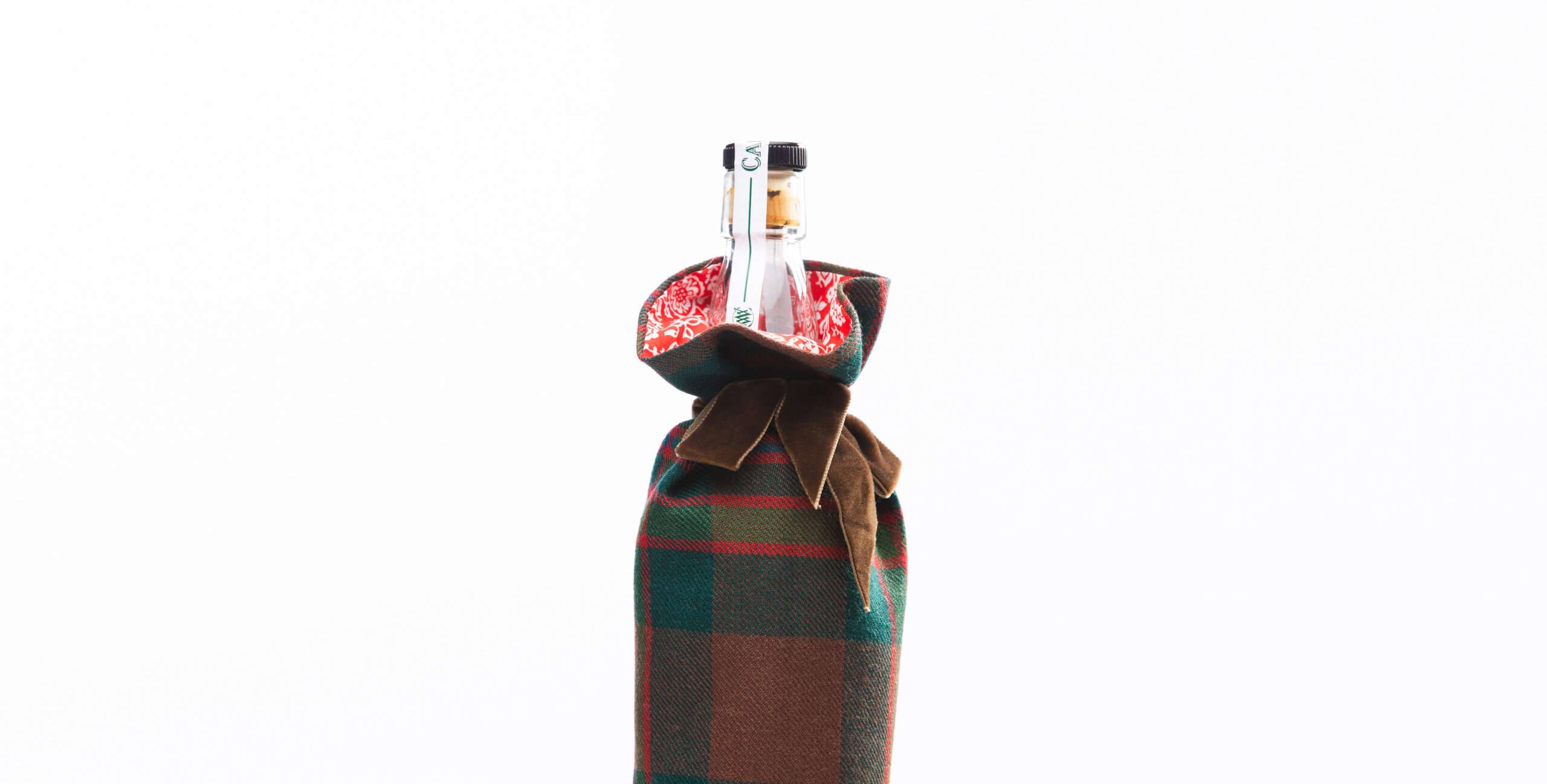 LoullyMakes Xmas produts 15 Banner scaled Many of us like to show our appreciation of friends, family , neighbours, colleagues & associates by giving a gift of the recipients favourite bottled refreshment - but a bottle isnt always an easy gift to wrap ! With these pretty, useful AND re-usable handmade Bottle Covers, however, you have a quick , easy and suitably seasonal solution ! Carefully handmade in our exclusive John Muir Way tartan, fully lined in a beautiful Liberty Art Fabric and finished with a gorgeous velvet ribbon tie-closure. They easily fit most average wine, whisky, spirit bottles (75cl-1L size) and can be re-used over and over again ! Please note the printed tana lawn lining and ribbon colour may vary from those pictured, but will always compliment the tartan.