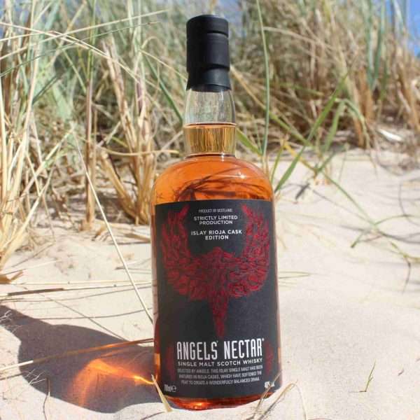 bottle of Angels' Nectar Islay Rioja Cask Edition Single Malt Scotch Whisky in sand dunes