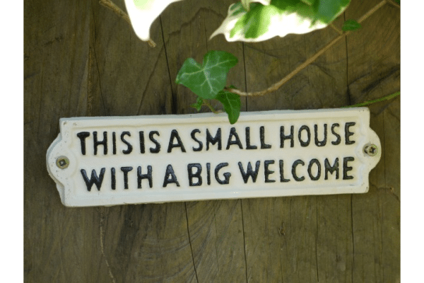 Cast iron This is a small house with a Big welcome wall Sign