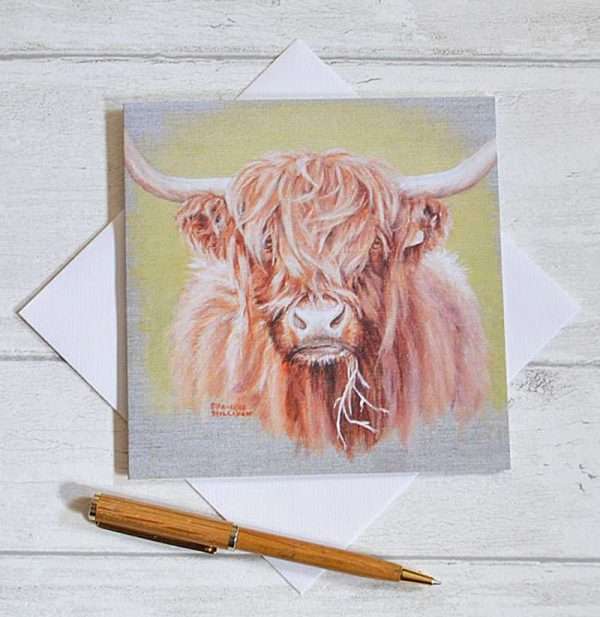 Square birthday card with highland cow head printed from my acrylic painting. Viewed flat from above on top of envelope with pen for scale
