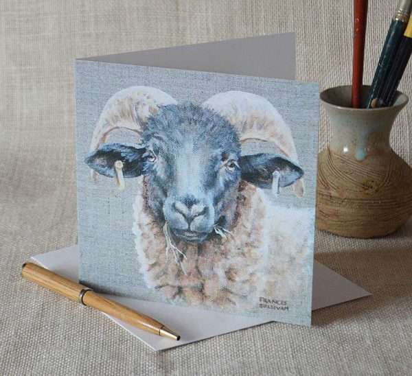 Norfolk Horn Sheep Birthday or Greetings card. Square and blank for your message. Viewed upright on top of envelope pen for scale in foreground and small vase with paintbrushes in background