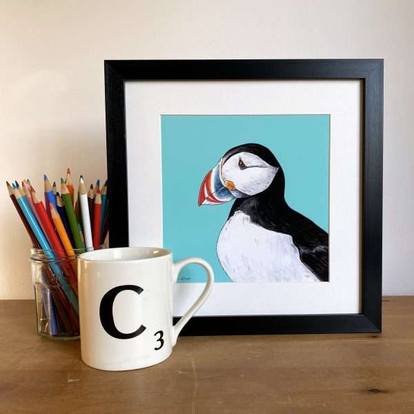 Puffin Scene mug and pencils scaled 10" x 10" art print of my original watercolour, fine liner and pencil illustration of a puffin on a blue background.