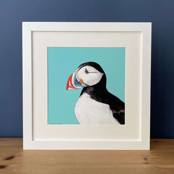 Puffin White Frame Blue scaled 10" x 10" art print of my original watercolour, fine liner and pencil illustration of a puffin on a blue background.