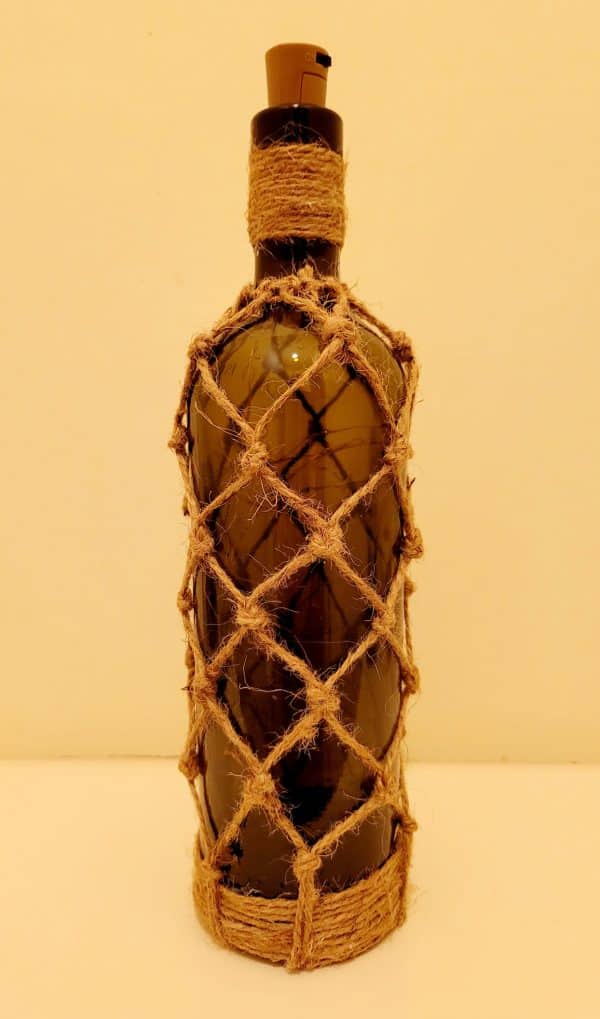 green glass wine bottle with jute twine braiding in a diamond pattern. Jute twine wound down the bottle neck. Jute twine wound around the bottom of the bottle. Cork LED lights non lit